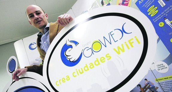 El consejero delegado y presidente de Gowex, Jenaro García, posa junto al logo de su empresa de wifi antes del escándalo por falsear las cuentas de la compañía.