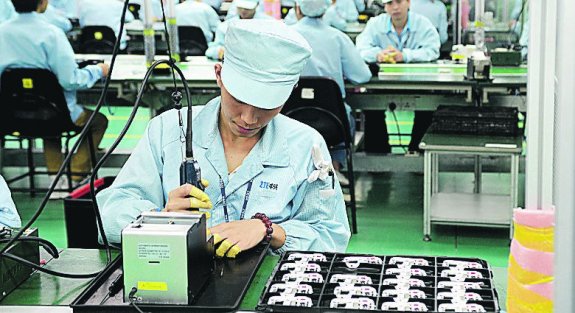 Trabajadores de la firma de móviles ZTE en su planta de Shenzen. :: Z. A.