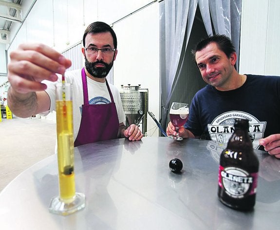 Los hermanos Iñigo y Pablo Olañeta examinan la calidad de su cerveza en su fábrica de Errenteria. 