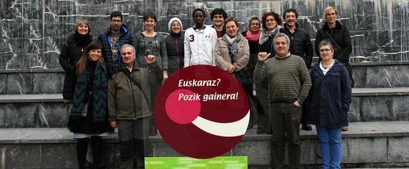 Mosaikoaren aurkezpen ekitaldia. Parte hartzaileak mosaikoan azalduko den 'Euskaraz? Pozik gainera!' logoarekin.