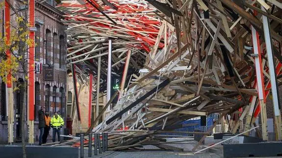 Técnicos observan los daños ocasionados tras derrumbarse parte de la estructura de la obra gigante 'The Passenger', del artista belga Arne Quinze, en Mons (Bélgica). 