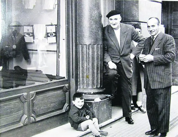 Años 50. José Markiegi en su sastrería con un cliente y acompañado de su hijo José Ramón.