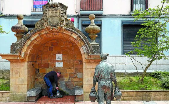 Para llevar. Un vecino recoge agua en la fuente de Urkizu, una imagen que se repite a diario desde hace años.