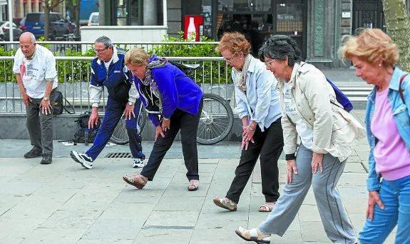 Estiramientos en la plaza de Okendo antes de iniciar la caminata. 