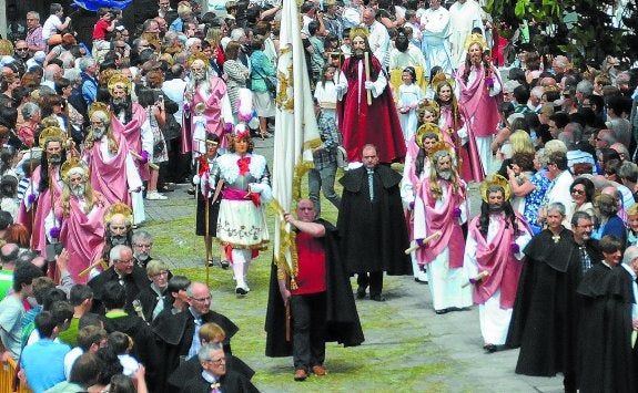 Gentío. Los miembros de la Cofradía del Apostolado, con San Miguel, los apóstoles y Cristo personificados, se abren paso. 