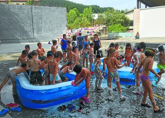 Baño de espuma. El cañón hizo las delicias de los escolares. Algunos tras sumergirse en la marea parecían muñecos de nieve. 