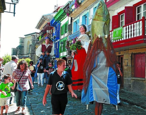 La comparsa de gigantes y cabezudos desfila por las calles del casco histórico de Hondarribia.