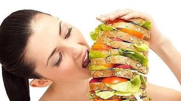 Una joven antes de pegar un mordisco a un sandwich vegetal gigante. 