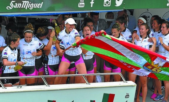 Nerea Pérez ondea la ikurriña mientras el resto de las batelerak festeja el triunfo.