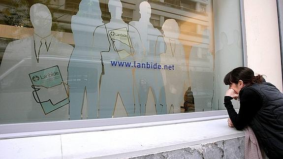 Una joven junto a una oficina de Lanbide. 