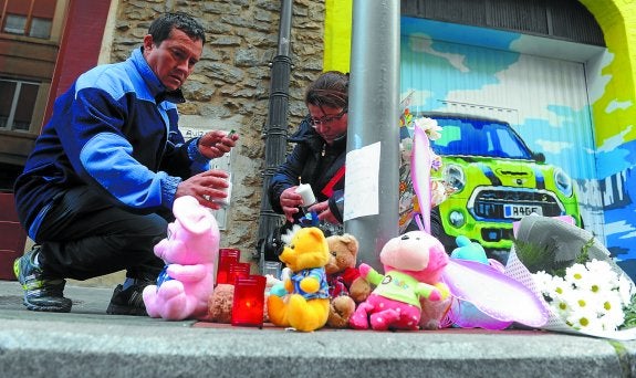 Una pareja coloca velas en el lugar donde cayó Alicia.