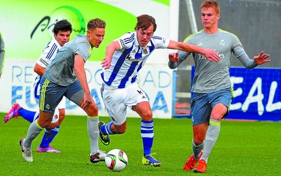 Bautista regatea a dos jugadores del Castilla durante el partido de ayer en Zubieta. 