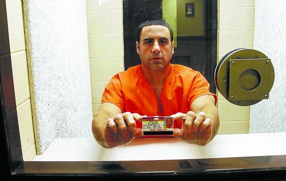 Pablo Ibar, tras la cristalera del corredor de la muerte, muestra su carnet.