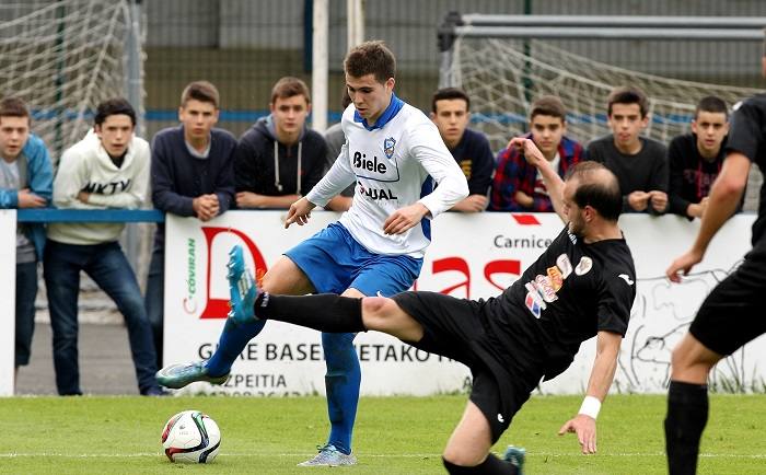 Un jugador del Lagun se dispone a regatear a uno del Águilas sobre el césped de Garmendipe.