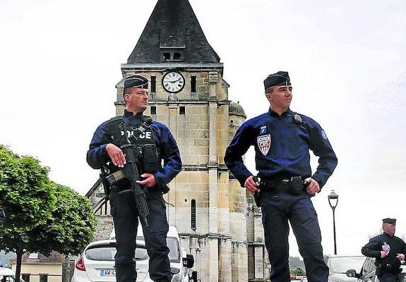 La Policía vigila la iglesia donde se cometió el crimen en Saint Etienne de Rouvray. A la derecha, un soldado patrulla las calles de Baiona, que celebra sus fiestas.