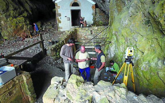 Los arqueólogos Zeberio, Moraza y Tapia, y las dos zonas de excavación. Delante de la ermita, la de la época paleolítica y, donde se halla la persona con prenda azul, la de hace 2.000 años. 