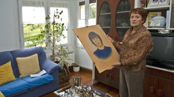 Nieves Fernandez, madre de Alberto Loza, muestra un retrato de su hijo. 