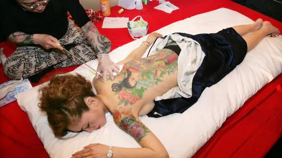 Un artista japonés Horiyoshi realizando tatuajes temporales en un club de Tokyo, Japón. 