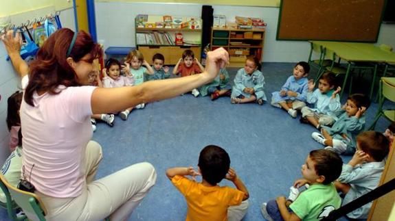 Un grupo de niños atiende en clase a su profesora.