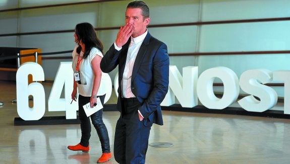 Ethan Hawke lanza un beso de despedida a los cámaras y fotógrafos tras su posado mañanero en el interior del Kursaal. 