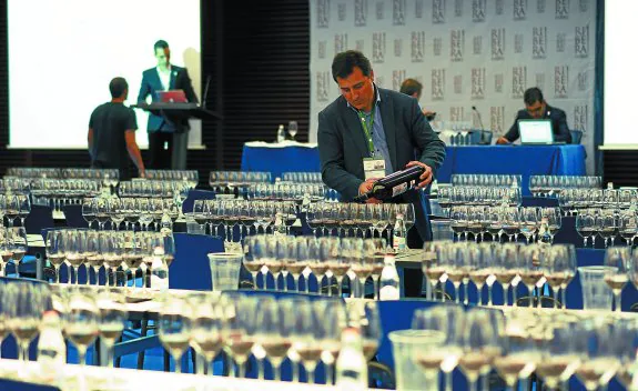 Los organizadores ultiman los detalles de la cata sirviendo en las copas el vino de Ribera del Duero. 