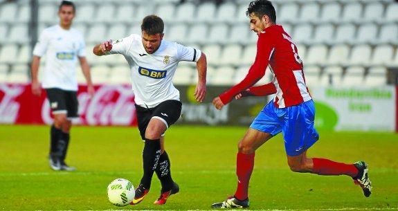 Jorge Galán trata de superar la presión de un jugador del Navalcarnero, ayer en el Stadium Gal. 