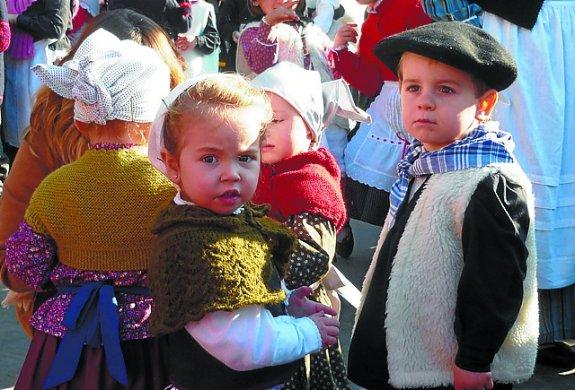 La feria de artesanos y productores locales estuvo muy animada. A la derecha, voluntarias preparando talos con txistorra. Abajo, dos niños de baserritarras. 