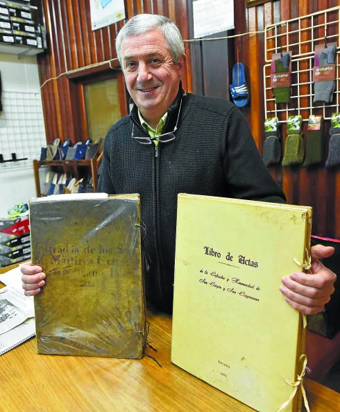 El tolosarra José Mari Arana con el antiguo y al actual libro de actas de la cofradía. 