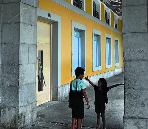 Unos niños juegan frente al inmueble de la plaza Euskal Herria que se transformará en hotel.
