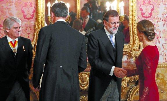 Mariano Rajoy saluda a la Reina Letizia ante Felipe VI, ayer en la recepción al cuerpo diplomático. 