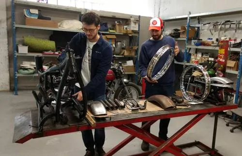 Hugo y Juanpa en el taller con una moto desmontada y lista para ser customizada.