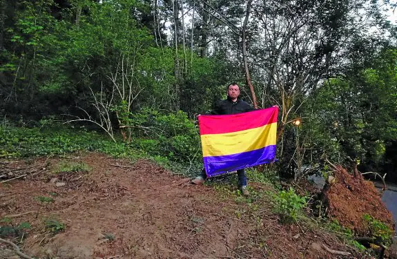 Fosa. Luis Mariano Gómez con la bandera republicana junto a la fosa donde podrían estár los cuerpos. 