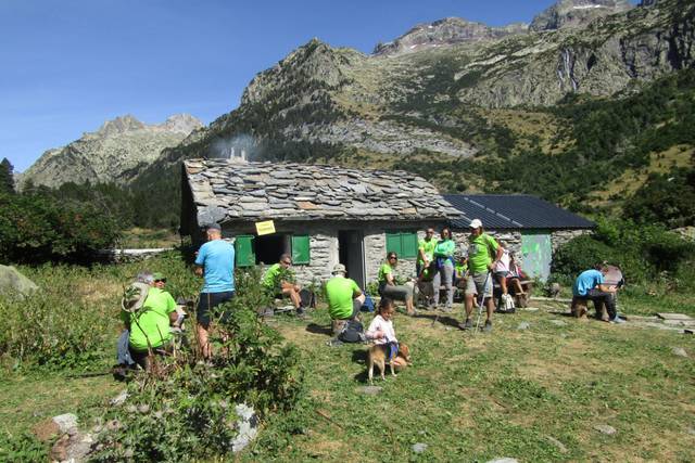 Varios excursionistas descansan juto a la célebre cabaña.