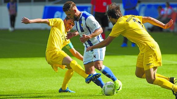 Kevin Rodriguez trata de zafarse de dos rivales del Navalcarnero, ayer en Zubieta. PEDRO MARTÍNEZ