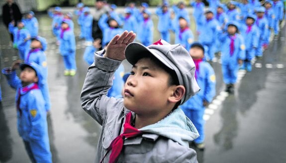 En la educación  de los niños de Yang Dezhi no falta el saludo  a la bandera  en disciplinada formación.