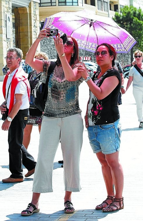 Dos turistas se protegían ayer del sol en Donostia.
