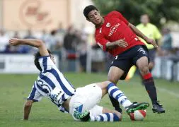 El realista Mikel Labaka se cruza para arrebatar el balón al mexicano de Osasuna Carlos Vela en el amistoso de Peralta. [JESÚS DIGES / EFE]