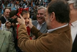 Rajoy acaricia a una niña momentos antes de iniciar su mitin en Zaragoza. [MARCOU / AFP]