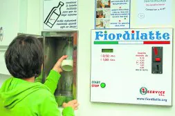Una mujer compra un litro de leche en la nueva máquina de Elizondo./ DEL CASTILLO