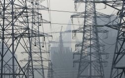 Torres de alta tensión suministran electricidad a una fábrica.