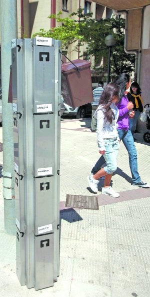 Un par de cubos marrones colgados ayer por la mañana en un poste. ::                             MICHELENA