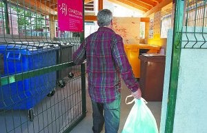 Una persona deposita basura en un punto de aportación. ::                             LOBO