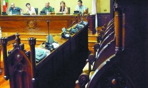 Alcalde y concejales de Bildu al fondo con los asientos de los ediles de la oposición vacíos en primer plano. ::
JUANFER