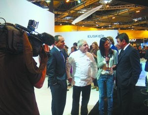 Feria Internacional. Páez, Muguruza y Santano atienden a una cadena de TV en el stand de Euskadi.