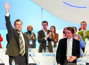 Mariano Rajoy saluda a los compromisarios ante José María Aznar tras ser reelegido presidente del PP. ::                             JULIO MUÑOZ / EFE