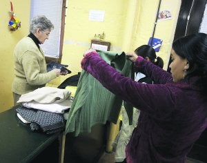 Necesidades básicas. Varias personas recogen ropa en uno de los locales de Cáritas. ::
MICHELENA