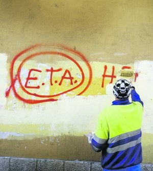 Un operario borra una pintada a favor de ETA en Gernika, un día después del alto el fuego definitivo. ::                             REUTERS