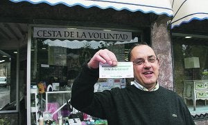 Xabier López de Munain. Con el boleto ganador, ante la gran cesta expuesta en Pinturas Alfredo. ::                             LIMIA