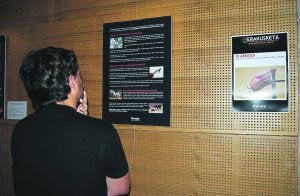 Pertsona bat erakusketan jarritako panela ikuste ari da. ::                             ALEX