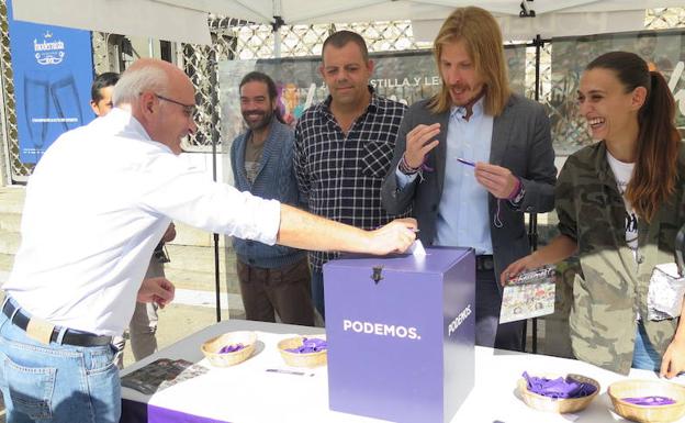 Un hombre deja su propuesta en la carpa de Podemos. 